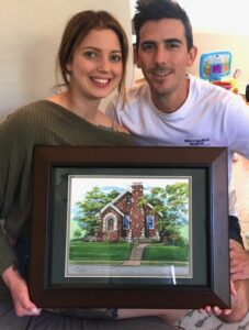 Young couple showing their house portrait gift